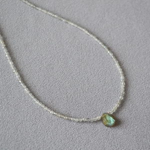 Detailed close-up of water drop labradorite pendant with shimmering blue-green hues