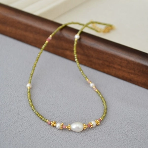 Détails macro de perles de zircon vert vintage et de perles d'eau douce sur collier