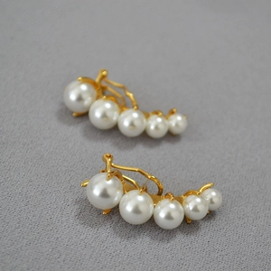Retro gold pearl crawler earrings with five white gradient pearls on grey background