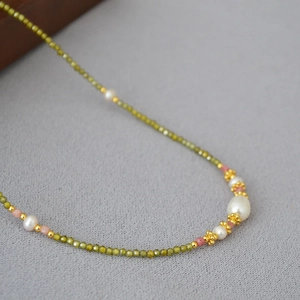 Détail macro du collier de perles minimaliste avec pierres vertes et perles d'eau douce