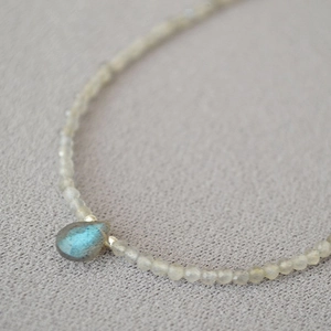 Macro shot of faceted labradorite beads and teardrop pendant with blue flash