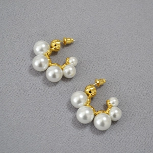 Minimalist C-shaped gold-plated brass hoop earrings with five graduated white pearls