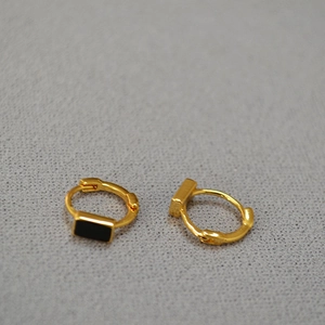 Detail of minimalist gold plated brass hoop earrings with black enamel rectangle inlay