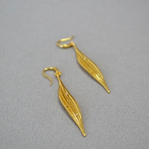 Elegant gold leaf earrings with zircons and brushed texture for a minimalist style