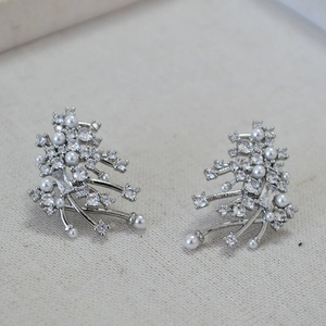 Detailed macro of flower cluster earrings with pearls and brilliant cubic zirconia stones