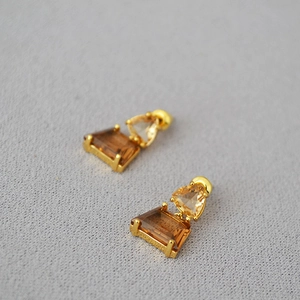 Retro geometric amber earrings with gold plating and trapezoidal gemstones on grey texture