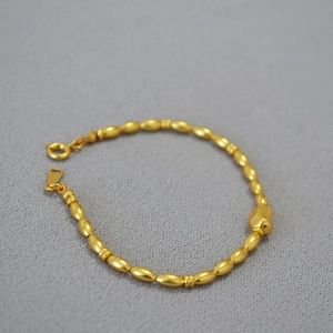 Detail of vintage brass gold beaded necklace featuring textured olive and hex beads