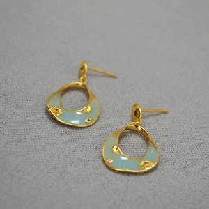 Detail of vintage gold-plated floral earrings with light blue enamel and rhinestones