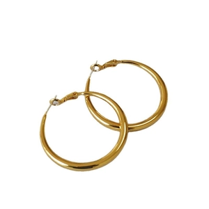 Polished oversized golden hoop earrings with lever-back closure on white background