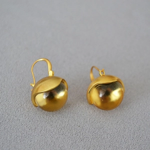 Macro shot of vintage brushed brass earrings with amber glass globes and hook design