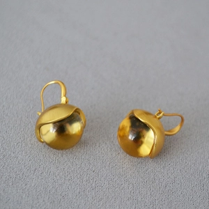 Close-up of vintage brass brushed gold earrings with amber glass flower bud drops