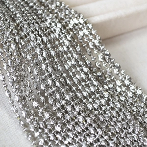 Detailed close-up of shiny faceted silver bead chain with textured metal surface