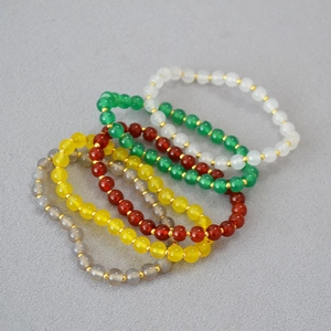 Close-up of stacked colorful agate beaded bracelets with small golden metallic spacers