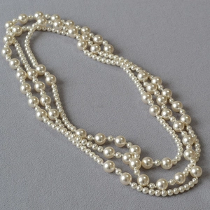 Close-up of layered faux pearl necklace showing elegant textures and glossy finish