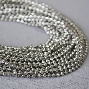 Macro detail of multi-strand silver beaded chain with polished metallic finish
