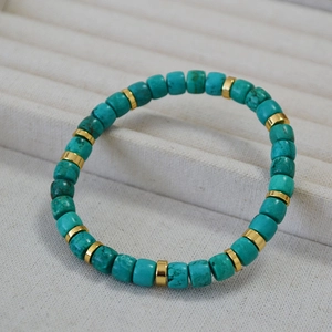 Macro shot of turquoise beads with gold metal spacers on a textured jewelry tray