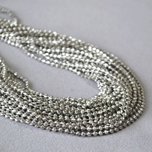 Close-up detail of multi-strand silver ball chain with polished metallic texture