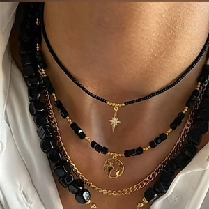 Detail of layered bohemian necklace with star pendant and black bead chain set
