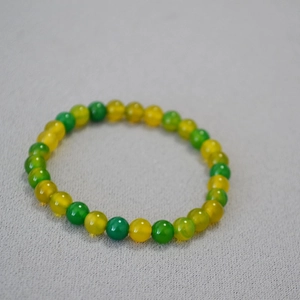 Detail of yellow and green agate beaded elastic bracelet with translucent stones