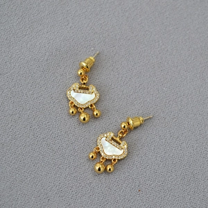 Detailed shot of golden Ruyi lock earrings with white shell inlay and zircon accents