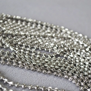 Close-up of sparkling silver faceted bead chains with intricate diamond-cut texture