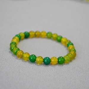 Detailed view of yellow and green agate beaded stretch bracelet with smooth polished stones