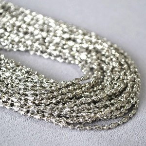 Macro shot of silver textured olive-shaped beads on a luxury minimalist necklace