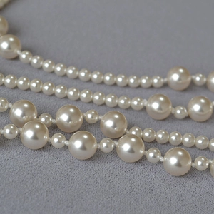 Macro shot of elegant multi-layered pearl necklace with gradient sizes and cream white luster