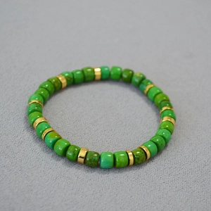 Detailed macro view of vintage turquoise cylinder beads and gold spacer beads on bracelet