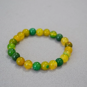 Macro detail of elastic bead bracelet with natural yellow and green agate stones
