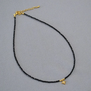 Double layered necklace with black faceted beads and gold star sun god pendant