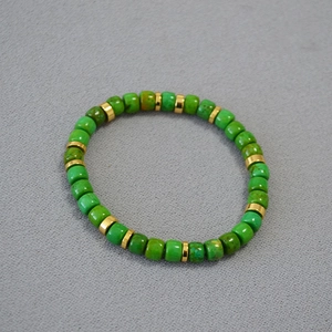 Macro view of turquoise beads with gold metal spacers on a handmade elastic bracelet