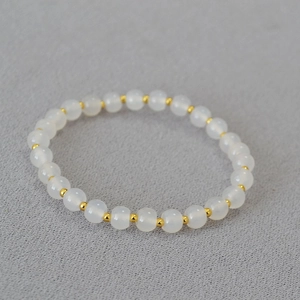 Detail of beaded bracelet with translucent white agate beads and gold spacer accents