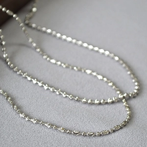 Close-up of sparkling faceted beads and round links on a silver-plated minimalist chain