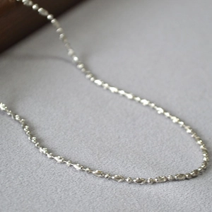 Detailed close-up of beaded silver chain link necklace with metallic texture