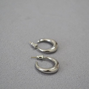 Close-up of polished silver C-shaped hoop earrings with 925 sterling silver needles