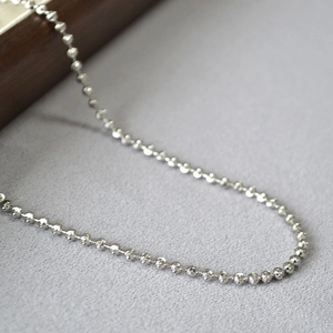 Detailed macro view of silver bead chain with sparkling diamond-cut faceted surface