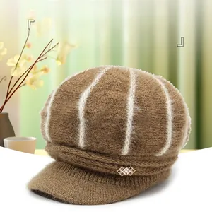 Detail of dark brown cable knit cap with white stripes and rhinestone buckle decoration