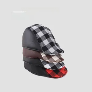 Detail of four plaid newsboy caps with leather brim showing various color patterns