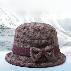 Close-up of deep purple plaid bucket hat featuring a decorative bow and warm knit texture