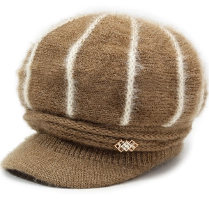 Detail of brown knitted baker boy hat with white plush stripes and gold rhinestone buckle