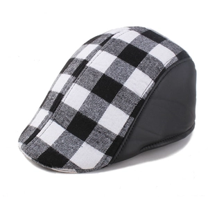 Close-up of black and white plaid beret with leather trim detail and stitching