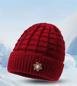 Close-up of wine red knit hat texture with pearl snowflake metal brooch detail