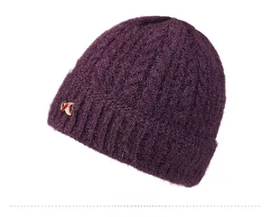 Detail view of deep purple cable-knit pattern and metallic logo on winter hat