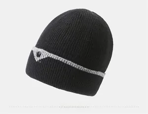 Side view of black ribbed knit beanie with grey stripes and decorative button detail