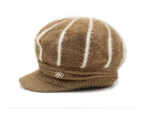 Detailed close-up of brown knit newsboy hat texture with stripes and gold rhinestone brooch