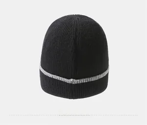 Detailed view of the rib-knit texture and grey striped hem on the black winter beanie