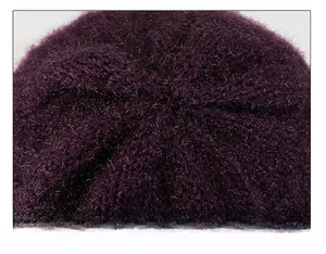 Macro detail of high-quality stitching on top of a purple knitted wool winter hat