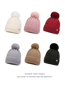 Six colors of cable knit winter hats with pom poms and metal H emblem detail