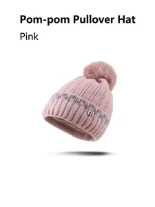 Detail der rosa Strickmütze mit Pompon, Rippenstruktur und silbernem Metall-M-Logo